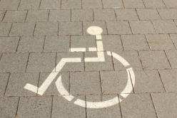 Das Bild zeigt einen auf das Kopfsteinpflaster gemalten Rollstuhl. Es verdeutlicht, hier dürfen nur schwerbehinderte Menschen ihr Fahrzeug parken.